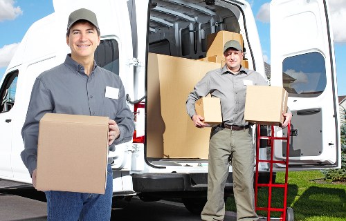 Movers carrying furniture through a narrow flat staircase